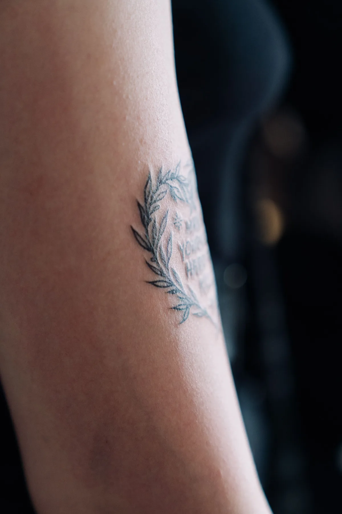 Tatouage au trait fin représentant une feuille, sur un avant-bras