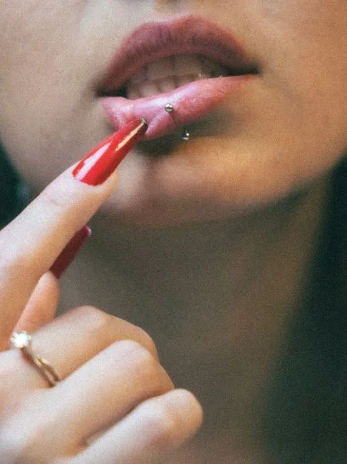Bouche en gros plan, bijou posé sous la lèvre.