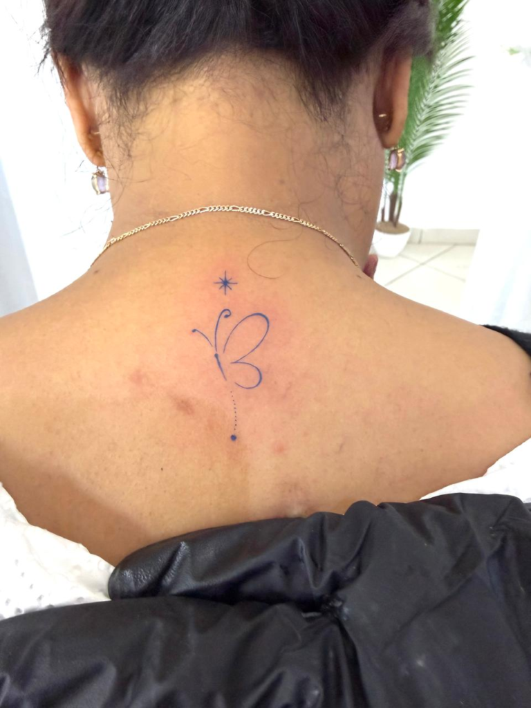 Papillon et étoile, haut du dos — tatouage réalisé au studio AUREA Lab, Antananarivo