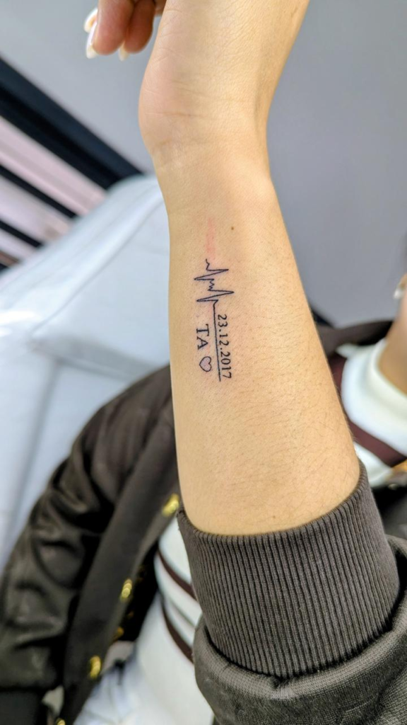 Battement de cœur et texte — tatouage réalisé au studio AUREA Lab, Antananarivo