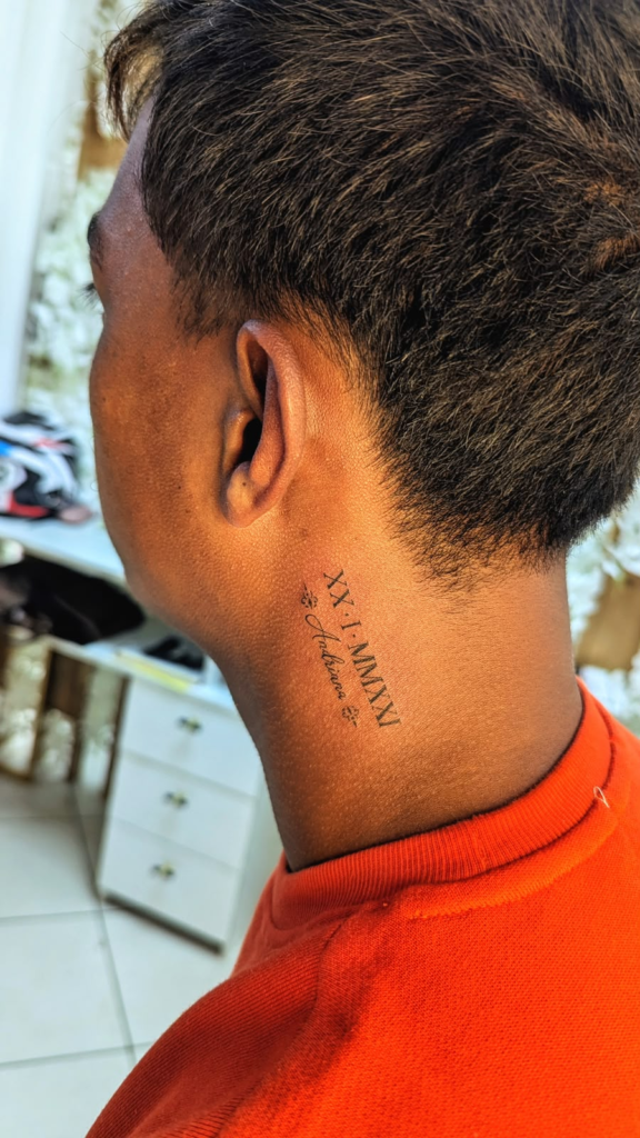 Date en chiffres romains sur la nuque — tatouage réalisé au studio AUREA Lab, Antananarivo